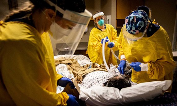 Nurse Connor Ramirez, respiratory therapist Kristin Hofland and nurse Julie Scebold work to transfer COVID-19 patient Thong Sengphirom to the ICU at Mary Greeley Medical Center in Ames, Iowa, Tuesday, Dec. 8, 2020.